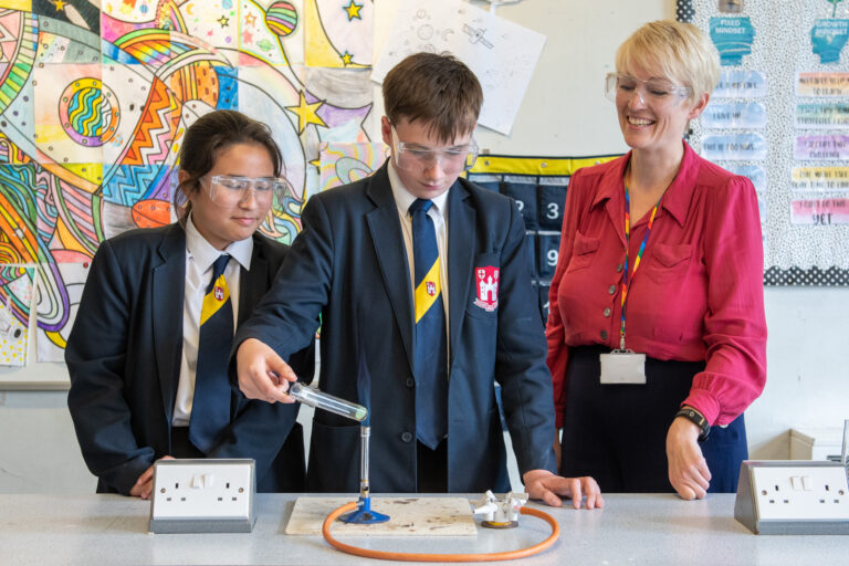 student doing an experiment in class with safety equipment on